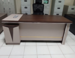 1800MM Executive L-Shaped Desk The 1800MM Executive L-Shaped Desk is a stylish and spacious office workstation designed for executives, managers, and professionals who need a practical and organized working environment. Its L-shaped configuration provides generous workspace for computers, documents, office accessories, and daily business activities. Designed to maximize corner space, this 1800MM L-shaped office desk provides an efficient workstation while maintaining a professional appearance. The extended desktop gives users room to separate computer equipment from paperwork, helping create a cleaner and more productive workspace. The executive design adds a sophisticated touch to modern offices. Its spacious layout is suitable for executive offices, management rooms, corporate workplaces, home offices, and other professional environments where functionality and presentation matter. Key Features 1800MM spacious desktop for comfortable working L-shaped configuration for efficient use of office space Executive-style design for a professional appearance Generous surface for computers, monitors, documents, and accessories